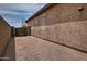 Side yard space with a decorative rock bed along the house and entry through a metal gate to the backyard at 3522 W Rushmore Dr, Anthem, AZ 85086