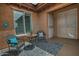 Cozy outdoor patio seating area with desert decor and a secure screen door at 3522 W Rushmore Dr, Anthem, AZ 85086