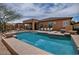 Sparkling backyard pool is surrounded by lounge chairs and a covered patio area at 3522 W Rushmore Dr, Anthem, AZ 85086