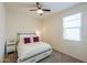 Cozy bedroom with neutral tones, a ceiling fan, and a window for natural light at 36467 W Pampoloma Ave, Maricopa, AZ 85138