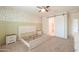 Bright bedroom with neutral carpet, barn door to bathroom, and accent wall with leaf-patterned wallpaper at 36467 W Pampoloma Ave, Maricopa, AZ 85138