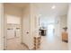 Bright hallway with tile floors, leading to the laundry room, kitchen and dining area at 36467 W Pampoloma Ave, Maricopa, AZ 85138