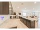 Open kitchen design with a large island and barstool seating, stainless appliances and granite counters at 36467 W Pampoloma Ave, Maricopa, AZ 85138