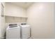 Well-lit laundry room featuring a washer and dryer, and built-in shelving at 36467 W Pampoloma Ave, Maricopa, AZ 85138
