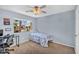 A blue bedroom with a twin bed, ceiling fan, a desk, and a bright window at 3786 S Chaparral Rd, Apache Junction, AZ 85119