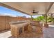 Built-in outdoor kitchen featuring grill, stainless steel storage, and stone counters under covered patio at 3786 S Chaparral Rd, Apache Junction, AZ 85119