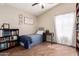 Inviting bedroom featuring a twin bed, tiled floor, and plenty of storage with built in and standing bookshelves at 3964 S Turquoise Dr, Buckeye, AZ 85326