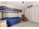 Bedroom with a bunkbed, neutral-colored carpet, beige walls, and a dark curtain making the space versatile at 3964 S Turquoise Dr, Buckeye, AZ 85326