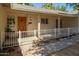 Covered front porch with decorative wood door, white railing, and flower accents at 3964 S Turquoise Dr, Buckeye, AZ 85326