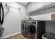 Well-lit laundry room featuring updated washer and dryer appliances, tiled floor, and lots of storage space at 3964 S Turquoise Dr, Buckeye, AZ 85326