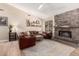 Inviting living room with stone fireplace, wood floors, a ceiling fan, and comfortable leather seating at 3964 S Turquoise Dr, Buckeye, AZ 85326
