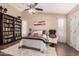 Spacious main bedroom with hardwood floors, a bookshelf wall, a ceiling fan and french door to the backyard at 3964 S Turquoise Dr, Buckeye, AZ 85326