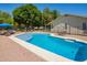 Backyard pool with lounge area, dining set, surrounded by a black fence and desert landscaping at 3964 S Turquoise Dr, Buckeye, AZ 85326
