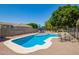 Sparkling blue pool with a white coping, surrounded by a patio with outdoor furniture and mature trees for shade at 3964 S Turquoise Dr, Buckeye, AZ 85326