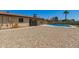Backyard featuring gravel, a pool, covered patio with bar seating, and desert landscaping at 4145 W Hayward Ave, Phoenix, AZ 85051
