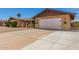 Wide driveway leading to a two-car garage, enhanced by desert landscaping and decorative touches at 4145 W Hayward Ave, Phoenix, AZ 85051