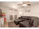 Comfortable living room featuring a plush leather sofa, tile floors, and a ceiling fan at 4145 W Hayward Ave, Phoenix, AZ 85051