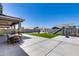Expansive backyard with an outdoor kitchen, fireplace, patio seating, and play area at 41650 W Barcelona Dr, Maricopa, AZ 85138