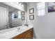 Bathroom featuring a vanity with white countertop, wood cabinets, and decorative accents at 41650 W Barcelona Dr, Maricopa, AZ 85138