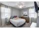 Bright bedroom with large window, plush bedding, ceiling fan, and decorative details at 41650 W Barcelona Dr, Maricopa, AZ 85138