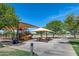 Community playground featuring covered seating, various play structures and multiple shade trees at 41650 W Barcelona Dr, Maricopa, AZ 85138