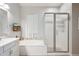 Clean bathroom featuring a soaking tub, glass-enclosed shower, and modern fixtures at 41926 W Sussex Dr, Maricopa, AZ 85138