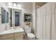 A bright bathroom offers a vanity with a sink, a toilet, and a shower with a curtain for essential functionality at 41926 W Sussex Dr, Maricopa, AZ 85138