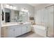 Bright bathroom with double sinks, a soaking tub, and a separate glass shower at 41926 W Sussex Dr, Maricopa, AZ 85138