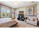 Serene bedroom with modern decor, backyard views, and a cozy seating area at 41926 W Sussex Dr, Maricopa, AZ 85138