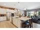 Open kitchen with a large island, stainless steel appliances, and seamless flow to the living area at 41926 W Sussex Dr, Maricopa, AZ 85138