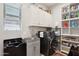 A well-organized laundry room includes a modern washer and dryer, a sink, and ample storage space at 41926 W Sussex Dr, Maricopa, AZ 85138