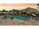 Backyard pool and waterfall feature with lush landscaping and comfortable lounging options at 41926 W Sussex Dr, Maricopa, AZ 85138