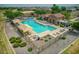 Aerial view of a community pool with lounge seating, umbrellas, and a clubhouse at 41926 W Sussex Dr, Maricopa, AZ 85138