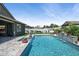The backyard features a sparkling pool and lounge area, creating a private and inviting outdoor oasis at 41926 W Sussex Dr, Maricopa, AZ 85138