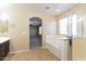 Bathroom featuring a tub, glass shower, and tile floors with a bedroom in the background at 42564 W Palmyra Ln, Maricopa, AZ 85138