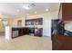 Modern kitchen with stainless steel appliances, dark wood cabinets, and tile flooring at 42564 W Palmyra Ln, Maricopa, AZ 85138