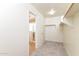 Spacious walk-in closet with lighting, a hanging rack, and an adjacent bathroom view at 42564 W Palmyra Ln, Maricopa, AZ 85138