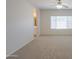 Bedroom showcasing carpet flooring, tan walls, a window, ceiling fan and archway leading to the bath at 44092 W Stonecreek Rd, Maricopa, AZ 85139