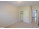 Bedroom featuring a sliding closet door, neutral carpet and paint, and a view into another room at 44092 W Stonecreek Rd, Maricopa, AZ 85139