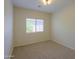 Cozy bedroom with neutral carpet, tan walls, a window, and a simple light fixture at 44092 W Stonecreek Rd, Maricopa, AZ 85139