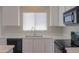 Bright kitchen showcasing white cabinets, a stainless steel sink under a window, and modern appliances at 44092 W Stonecreek Rd, Maricopa, AZ 85139
