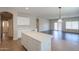 Open-concept kitchen with a spacious island, white cabinets, and a view into the living area at 44092 W Stonecreek Rd, Maricopa, AZ 85139