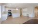 Open concept kitchen with white cabinets, a large island, and a view into the living area at 44092 W Stonecreek Rd, Maricopa, AZ 85139