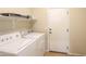 Laundry room features a white washer and dryer with shelving at 44092 W Stonecreek Rd, Maricopa, AZ 85139