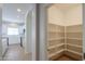 Spacious walk-in pantry with built-in shelving, accessible from the kitchen area at 44092 W Stonecreek Rd, Maricopa, AZ 85139