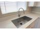 Close-up of a stainless steel kitchen sink with a modern faucet and quartz countertops at 44092 W Stonecreek Rd, Maricopa, AZ 85139