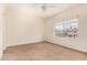 Bright bedroom featuring a ceiling fan, carpet flooring, and a view of the outdoors at 4455 E Paradise Village S Pkwy # 1057, Phoenix, AZ 85032