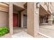 Close up of townhome entryway showing grey garage door and red front door at 4455 E Paradise Village S Pkwy # 1057, Phoenix, AZ 85032
