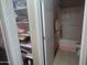 Hallway closet with towels, alongside bathroom with pink accents and shower at 4733 W Eva St, Glendale, AZ 85302