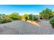 Charming backyard featuring a patterned brick patio and lush desert landscaping with raised garden beds at 47719 N Camino Del Sol --, Gold Canyon, AZ 85118